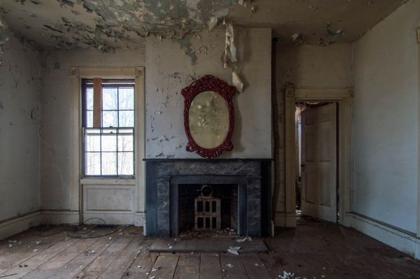 Photo of a mirror in an abandoned, disused house.