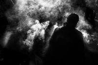 Silhouette of a person surrounded by white smoke.